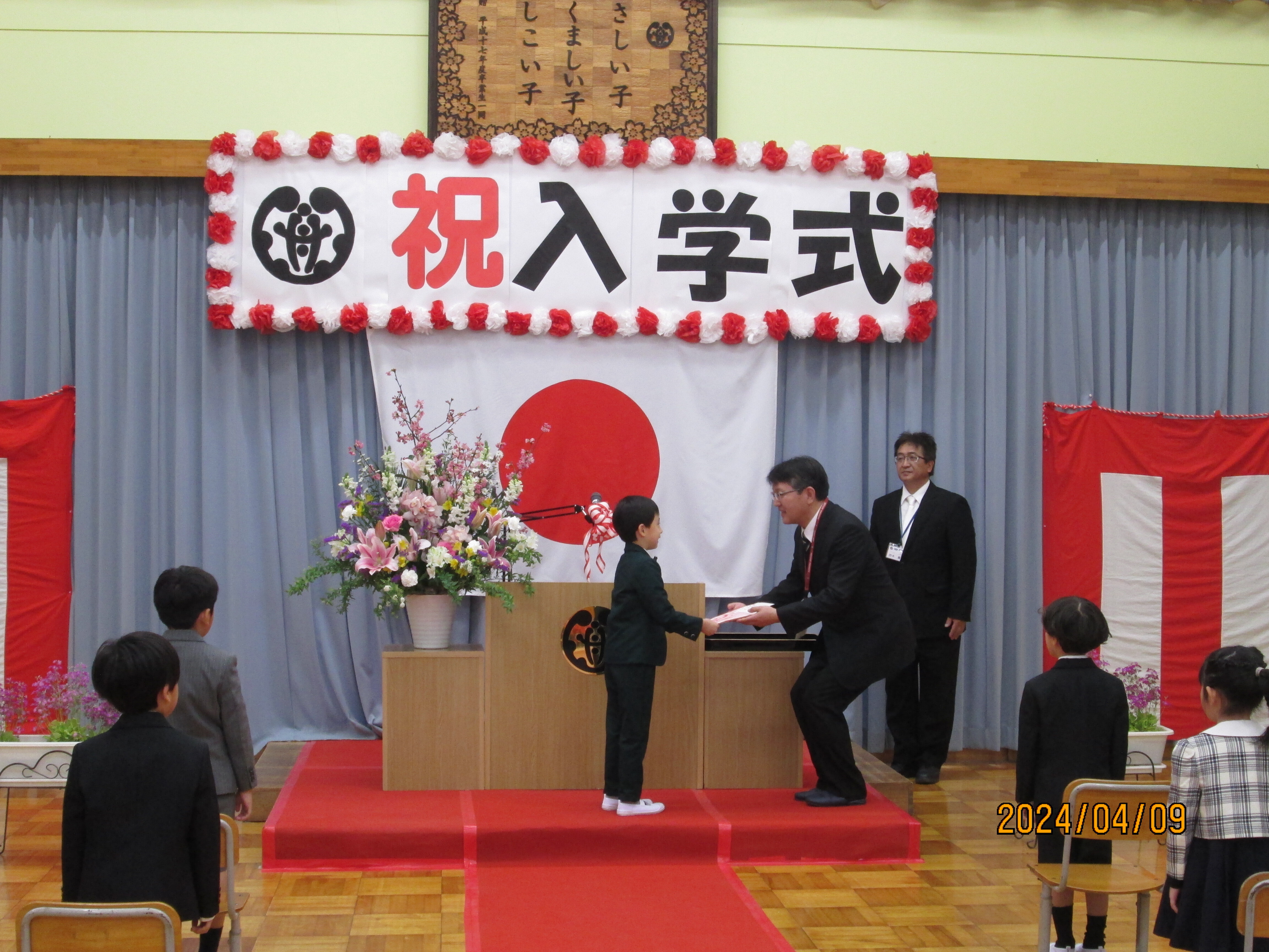 教科書給与　新入生代表が受け取る写真