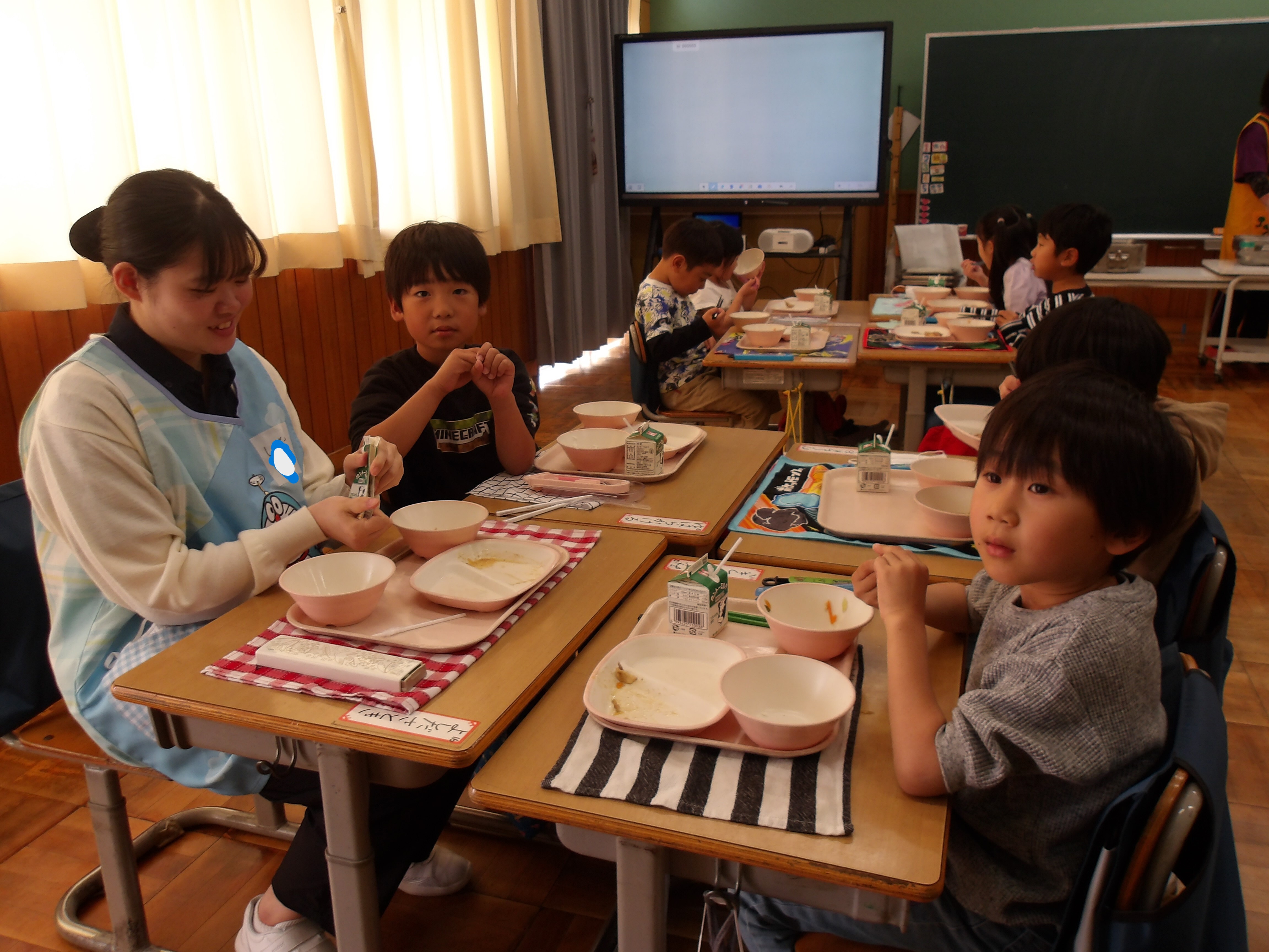 1年生と一緒に給食を食べている写真
