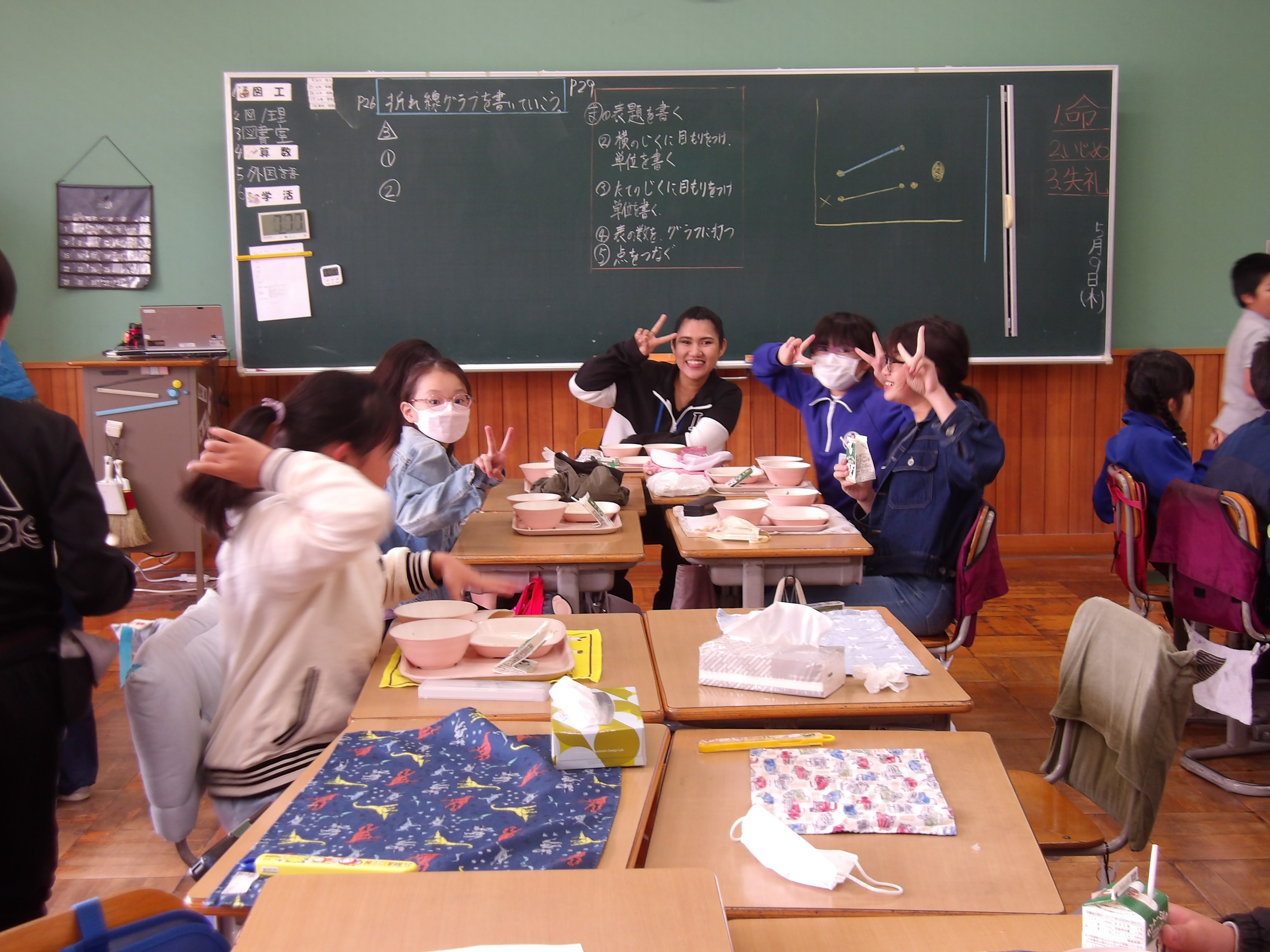 外国語の先生と給食を食べている写真